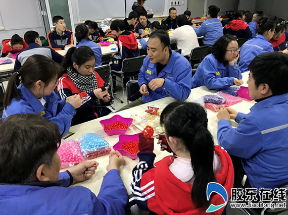 企业员工与孩子们沟通互动,共同制作手工艺品